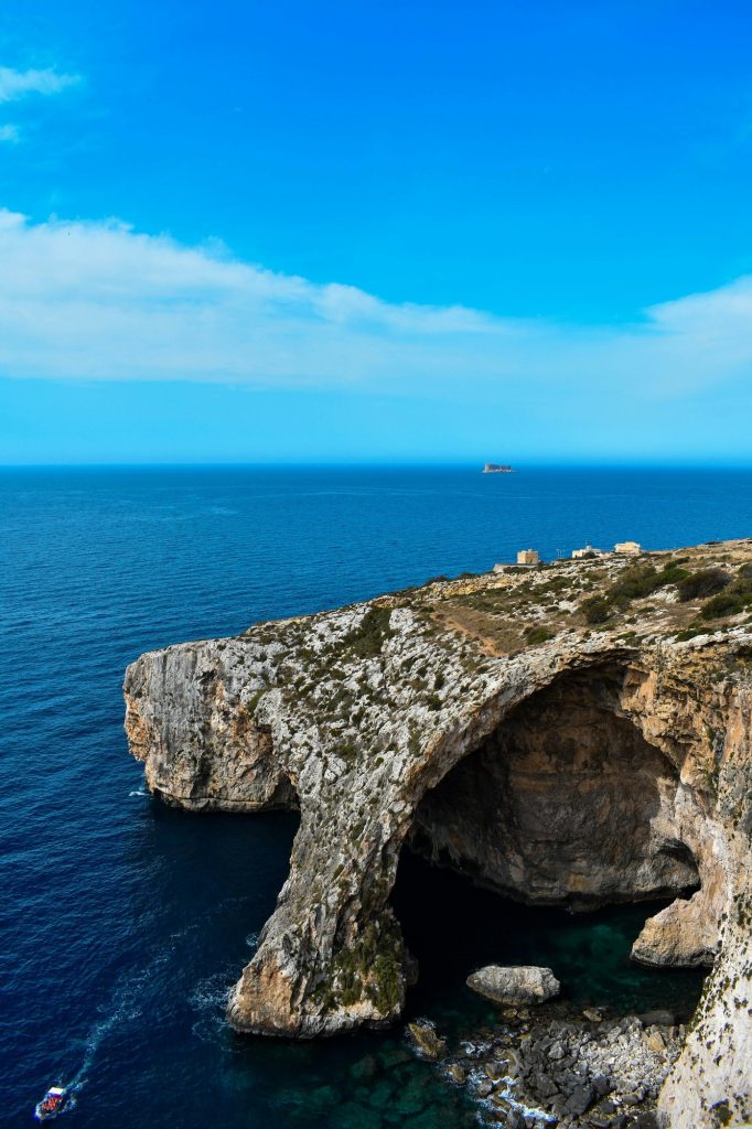 Skalny łuk Blue Grotto nad granatowym morzem, widok z góry