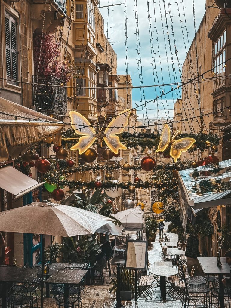 Świąteczne dekoracje nad uliczką z kawiarniami w Valletcie