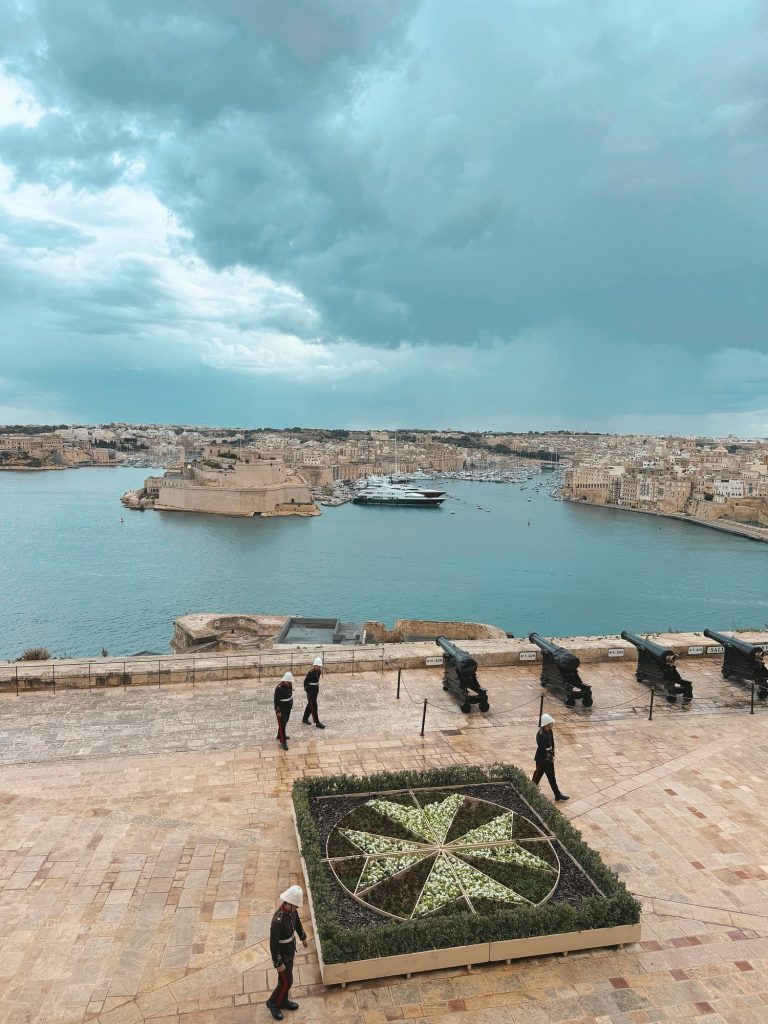 Saluting Battery pod Upper Barrakka Gardens w Valletcie – armaty i widok na Grand Harbour w pochmurny grudniowy dzień